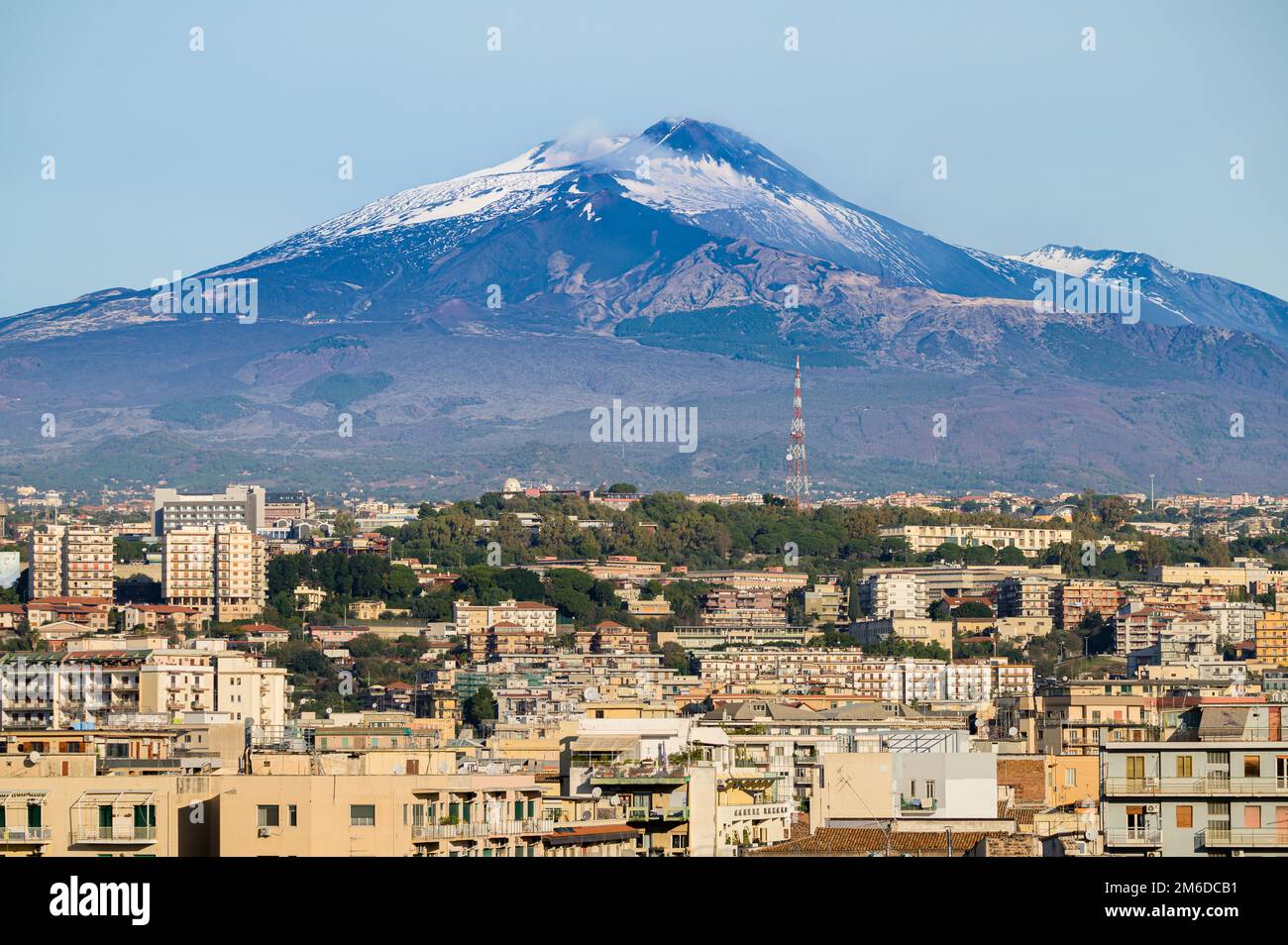 Luftaufnahme auf die Dächer im Stadtzentrum von Catania und den schneebedeckten Gipfel des Ätna-Vulkans bei Sonnenaufgang in Sizilien, Italien Stockfoto