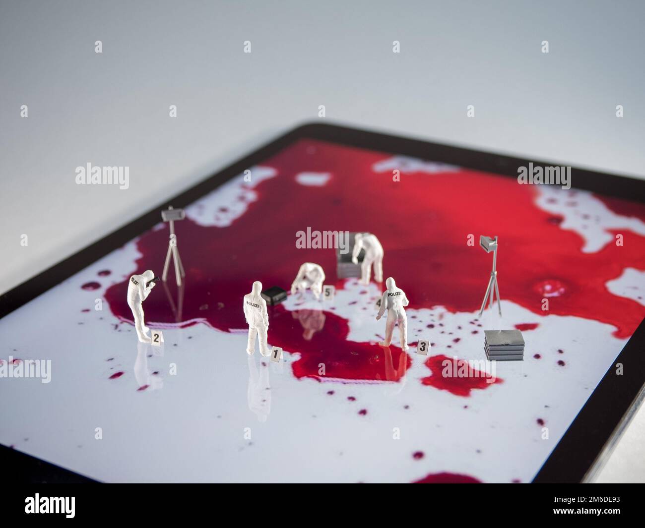 Miniatur-Forensiker untersuchen den Bildschirm eines Tablet-Computers Stockfoto