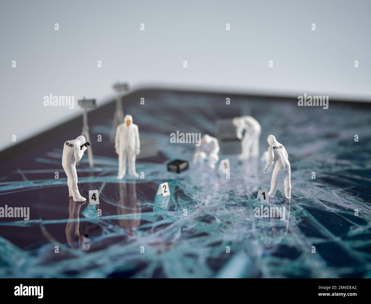 Kleine forensische Personen, die einen Tablet-Computer untersuchen Stockfoto