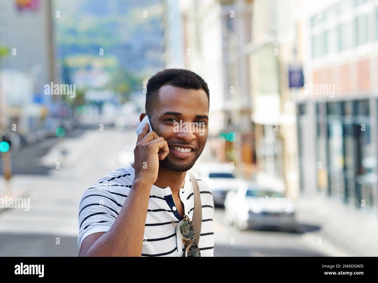 Ich bin auf dem Weg dorthin... Ein gutaussehender afroamerikanischer Geschäftsmann auf seinem Handy, während ich in der Stadt war. Stockfoto