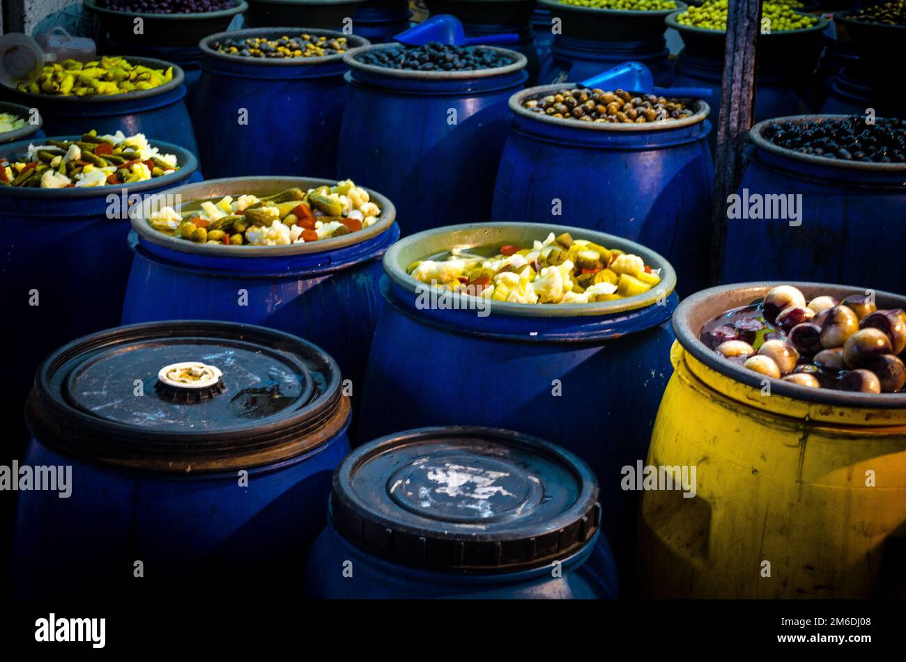 Verschiedene Gemüsesorten, Früchte und Gurken auf blauen Fässern auf einem Markt in Santiago de Chile Stockfoto
