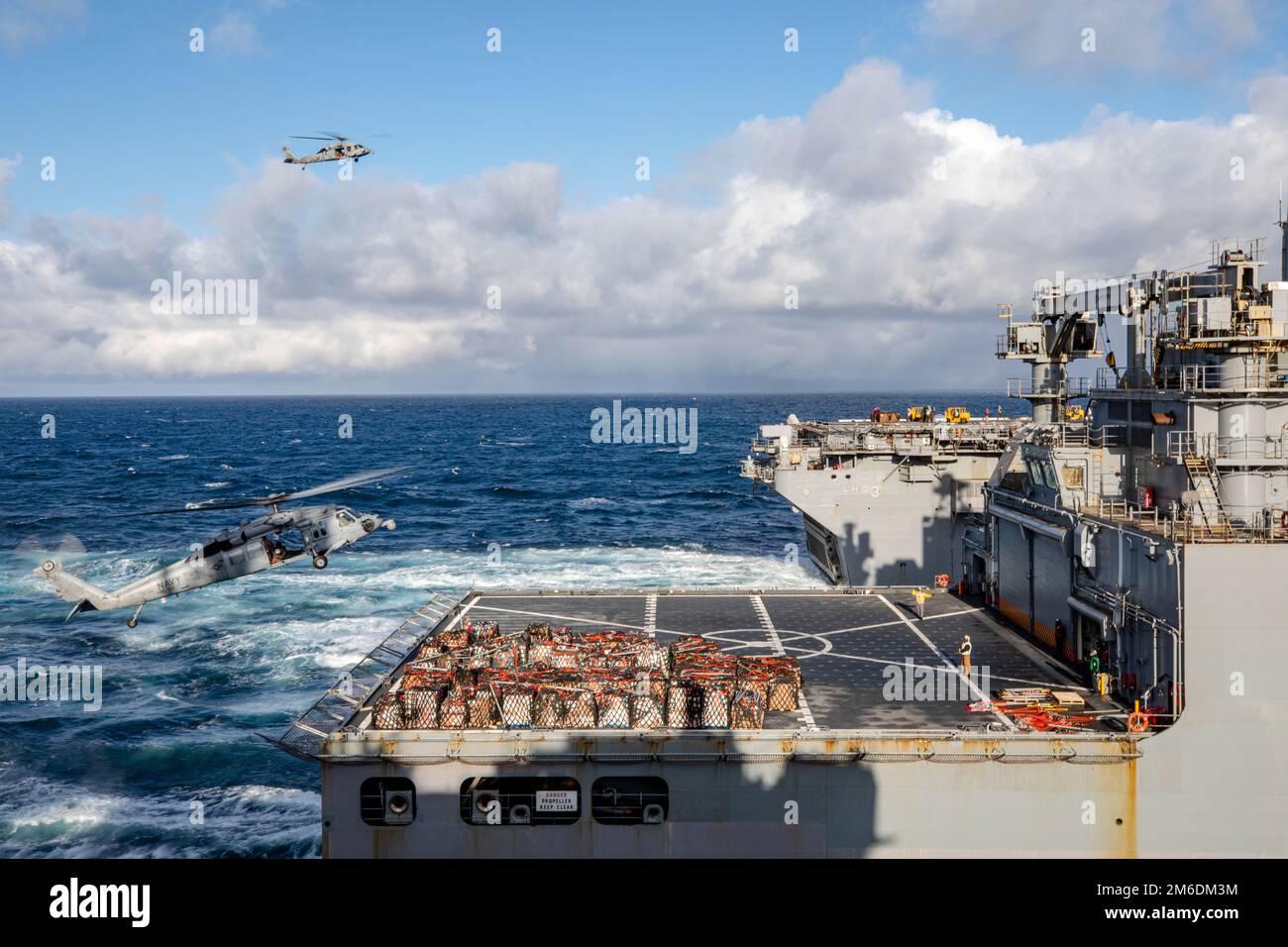 ATLANTIK (25. April 2022) HM-60 Seahawks angeschlossen an Helicopter Squadron Command 26 und Helicopter Squadron Command 22, Flugpakete vom Trockenfrachtschiff der Lewis- und Clark-Klasse USNS Robert E. Peary (T-AKE-5), am nächsten, zum dritten Amphibienschiff USS Kearsarge (LHD-3), während einer vertikalen Auffüllung am 25. April 2022. Gunston Hall, der Kearsarge Amphibious Ready Group zugeteilt, befindet sich auf einem geplanten Einsatz unter dem Kommando und der Kontrolle der Task Force 61/2, während er in der sechsten US-Flotte zur Unterstützung von US-, Alliierten- und Partnerinteressen in Europa und Afrika tätig ist. Stockfoto