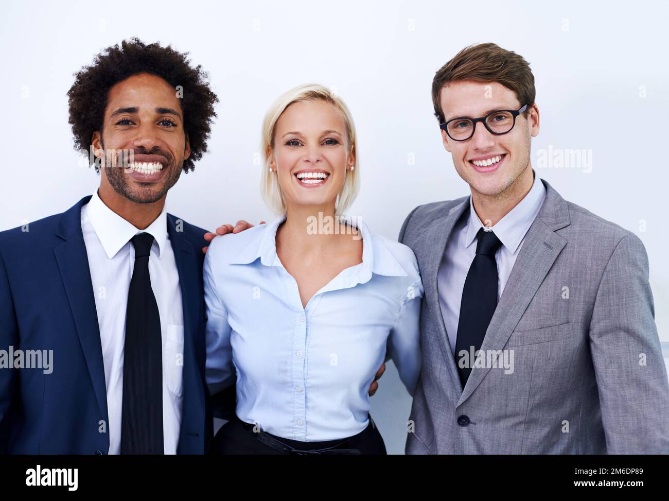 Positiv über unsere Leistung. Porträt von drei glücklichen Kollegen, die selbstbewusst in die Kamera lächeln. Stockfoto