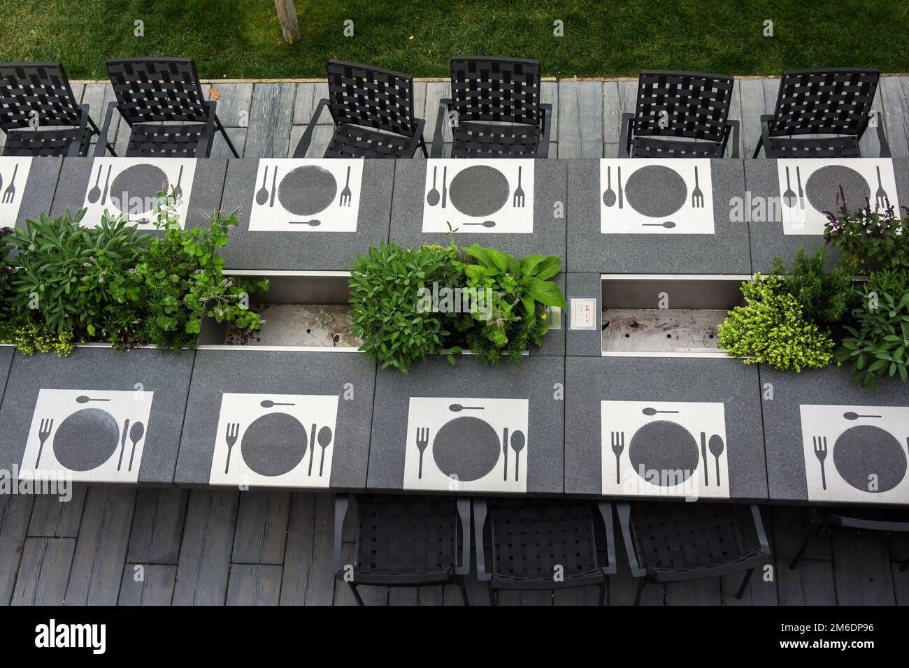 Betontisch mit Geschirr und Stuhl im Freien Stockfoto