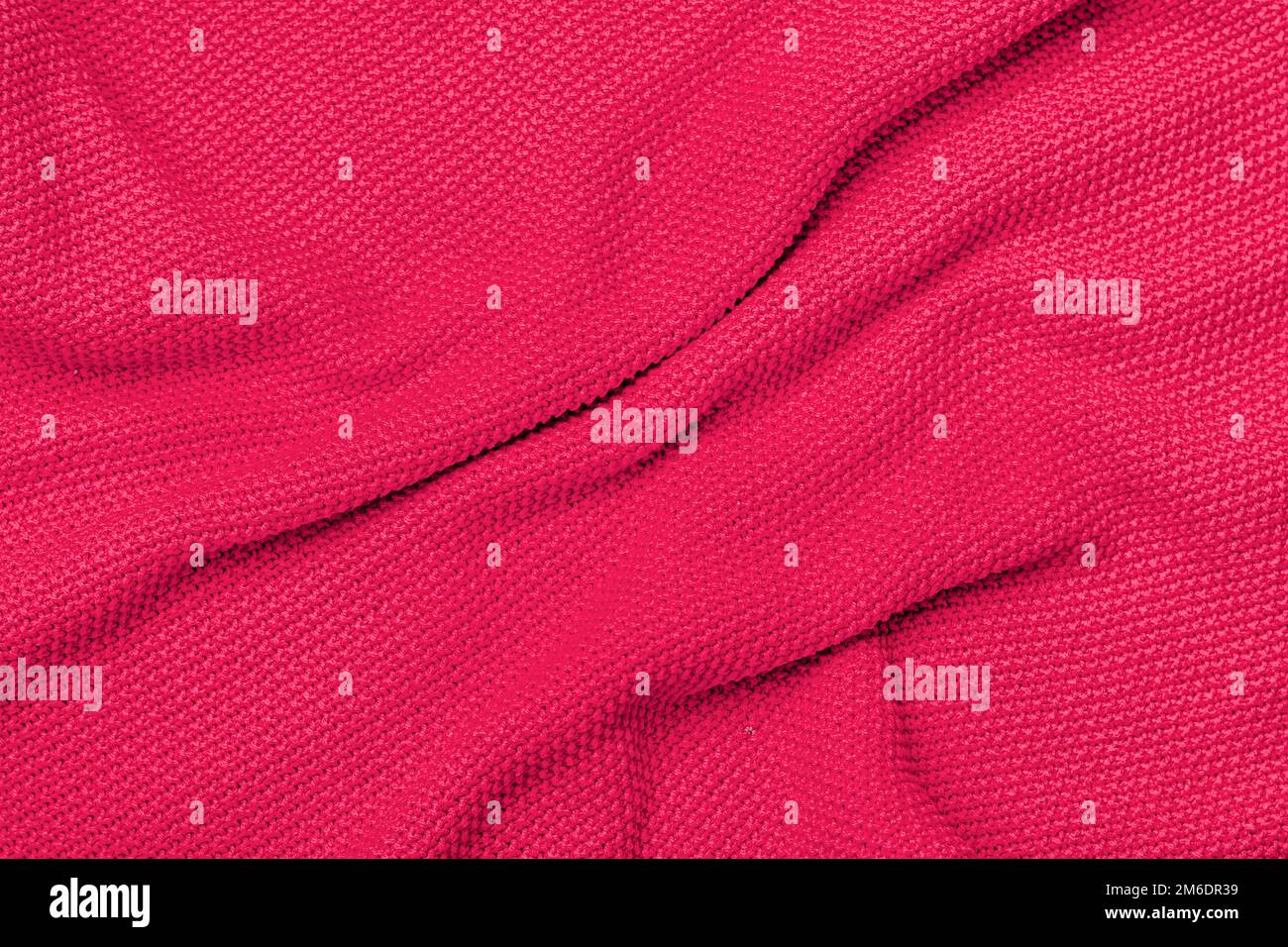 Die Konsistenz eines warmen Strickpulvers. Wunderschönes, handgestricktes, sich wiederholendes Muster. Darstellung der Pantone-Farbe des Jahres 2023 viva magenta. Stockfoto