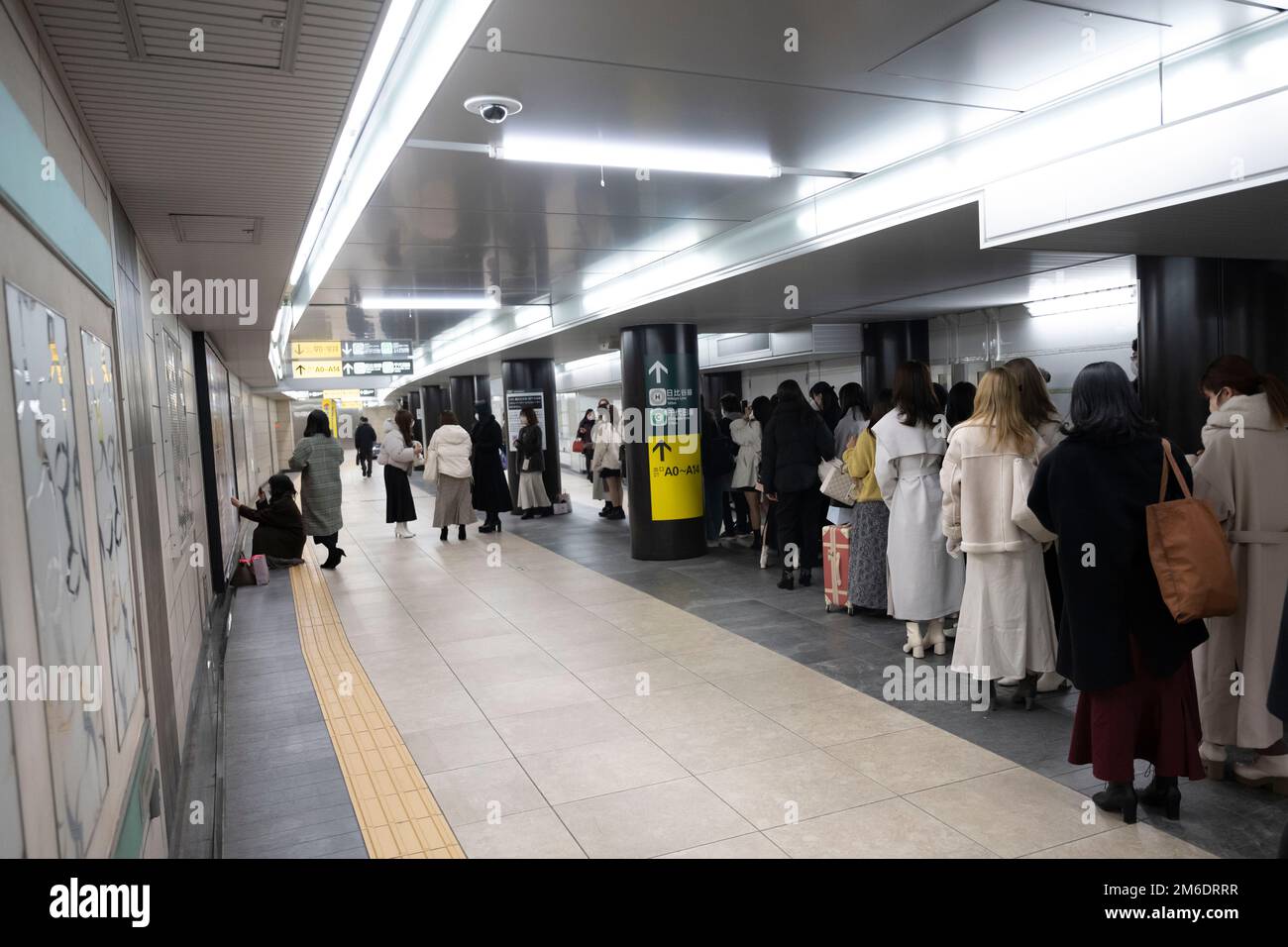 Tokio, Japan. 3. Januar 2023. Frauen stehen Schlange, um Fotos zu machen mit einer Werbung für das J-Pop Musical und die akrobatische Idol-Gruppe Johnny's World in Hibiya Station an der Tokyo Metro und Toei Subway. Ginza ist ein beliebtes, gehobenes Einkaufsviertel, bekannt für seine Auswahl an Luxusgeschäften und Reichtum in der Fifth Avenue. Es liegt neben der Stadt Chiyoda, der Heimat des Kaiserpalastes und des Sitzes der japanischen Regierung. (Kreditbild: © Taidgh Barron/ZUMA Press Wire) Stockfoto