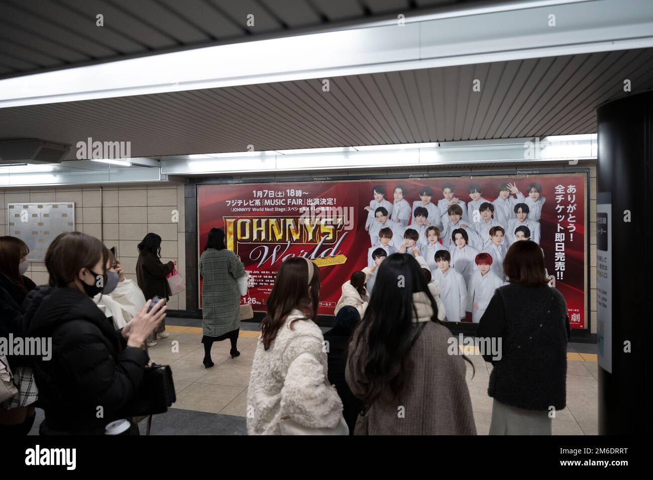 Tokio, Japan. 3. Januar 2023. Frauen stehen Schlange, um Fotos zu machen mit einer Werbung für das J-Pop Musical und die akrobatische Idol-Gruppe Johnny's World in Hibiya Station an der Tokyo Metro und Toei Subway. Ginza ist ein beliebtes, gehobenes Einkaufsviertel, bekannt für seine Auswahl an Luxusgeschäften und Reichtum in der Fifth Avenue. Es liegt neben der Stadt Chiyoda, der Heimat des Kaiserpalastes und des Sitzes der japanischen Regierung. (Kreditbild: © Taidgh Barron/ZUMA Press Wire) Stockfoto