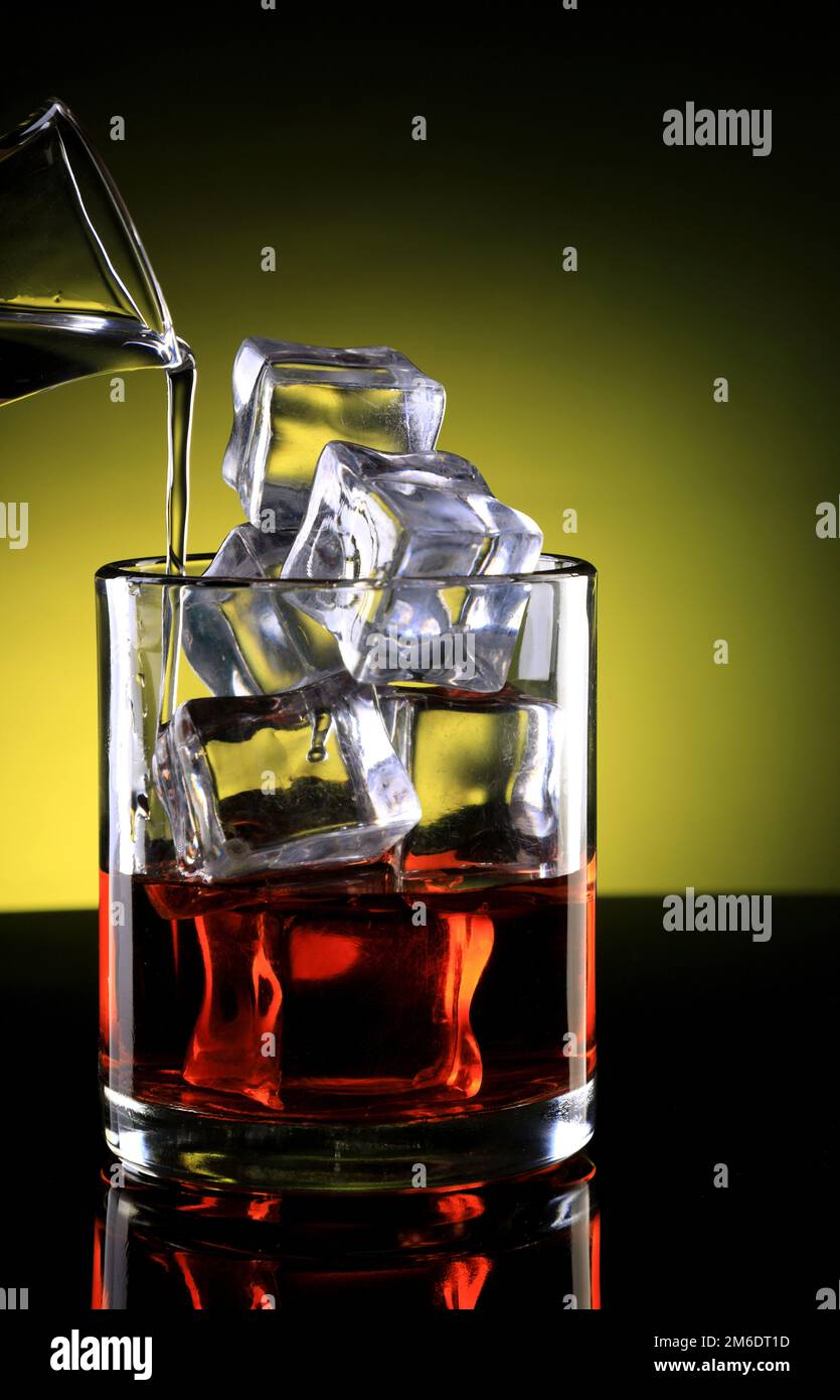 Whiskyglas mit Eiswürfeln und Eingegossenem Getränk Stockfoto