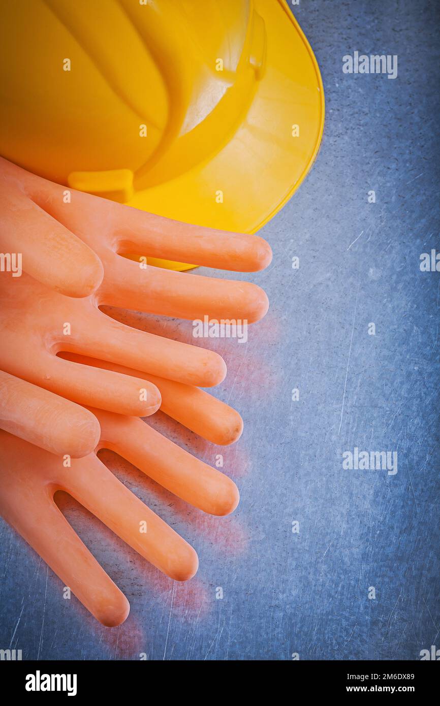 Isolierhandschuhe Schutzhelm auf metallischem Hintergrund. Stockfoto