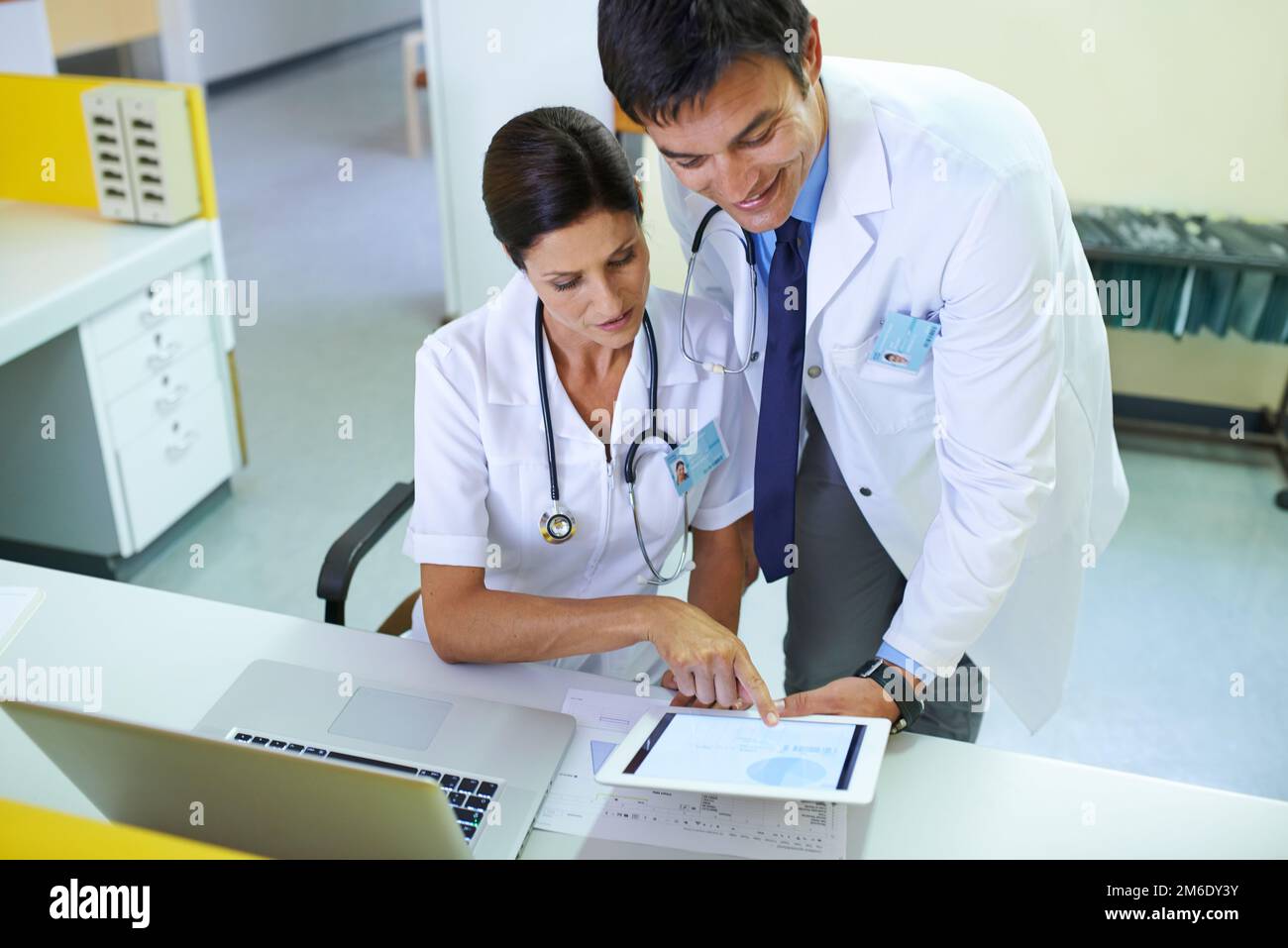 Die Beweise deuten darauf hin, dass es ihnen besser gehen sollte. Ein medizinisches Team, das eine Patientenakte durchsucht. Stockfoto