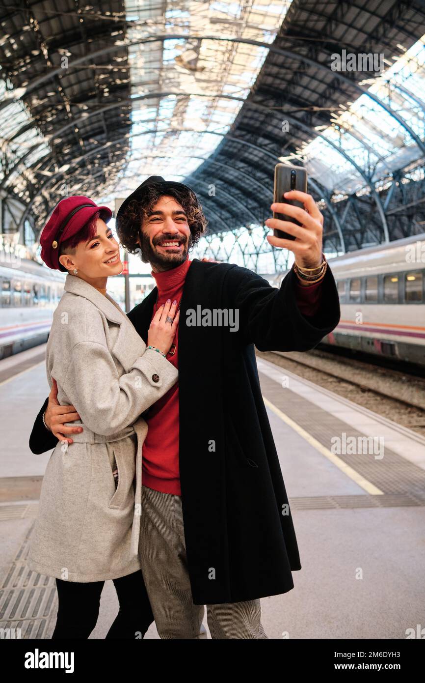 Glückliches Paar, das ein Selfie in einen Bahnhof macht Stockfoto