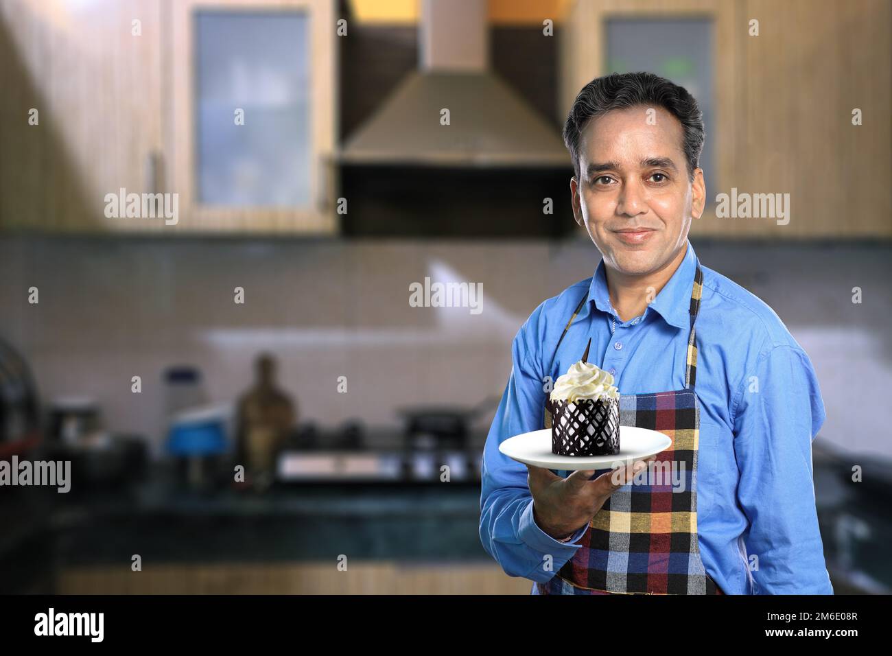Indischer Koch mit süßer Kuchen und Kücheneinrichtung Stockfoto