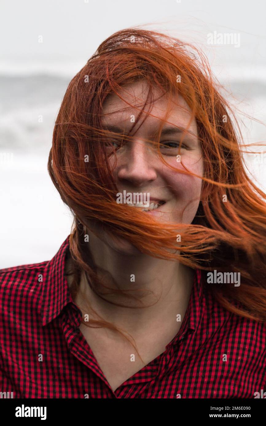 Nahaufnahme einer glücklichen rothaarigen Frau mit schmutzigen Haaren auf einem Strandporträtbild Stockfoto