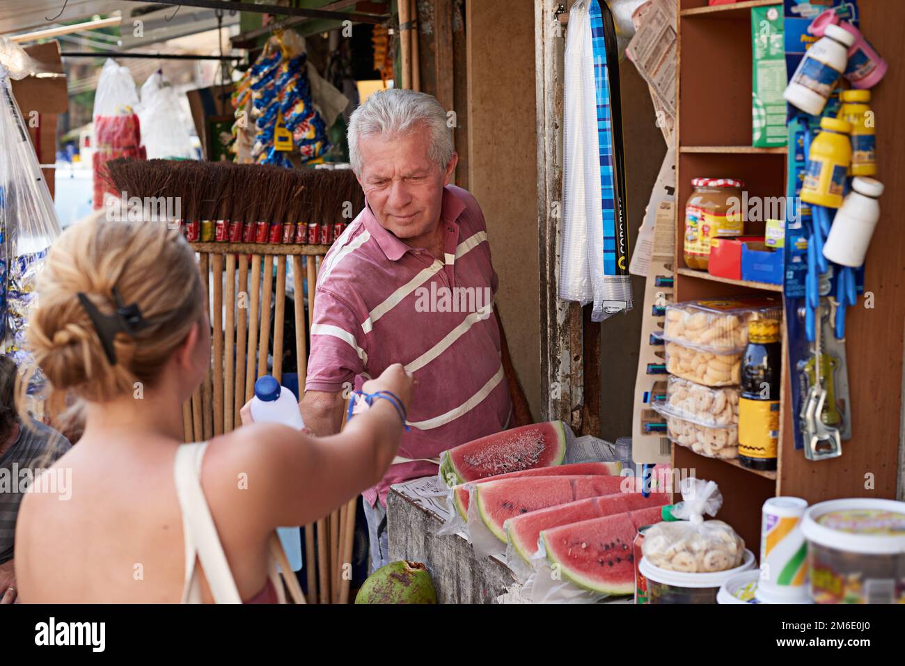 Ihr freundlicher Straßenverkäufer. Ein Straßenverkäufer, der einem Kunden an seinem Stand hilft. Stockfoto