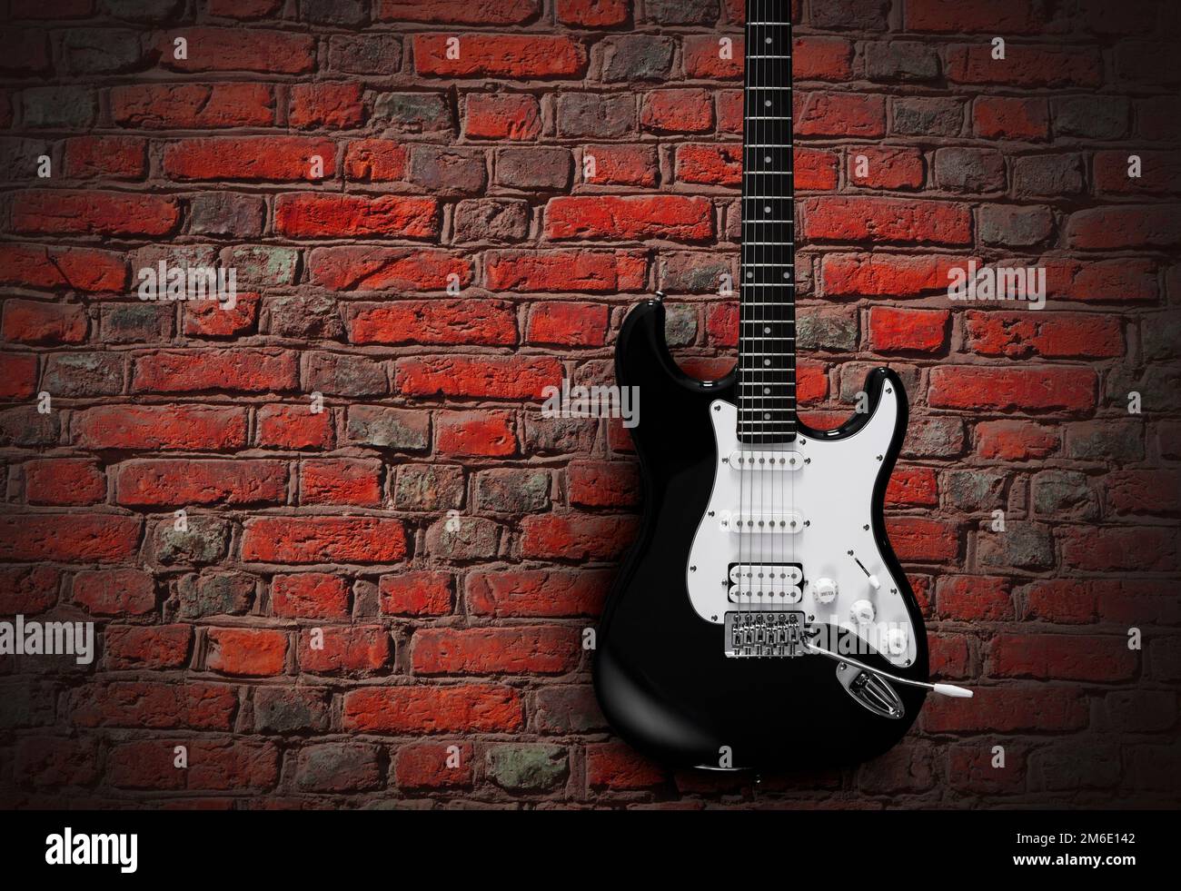 Schwarze elektrische Gitarre auf rotem Backsteinhintergrund Stockfoto