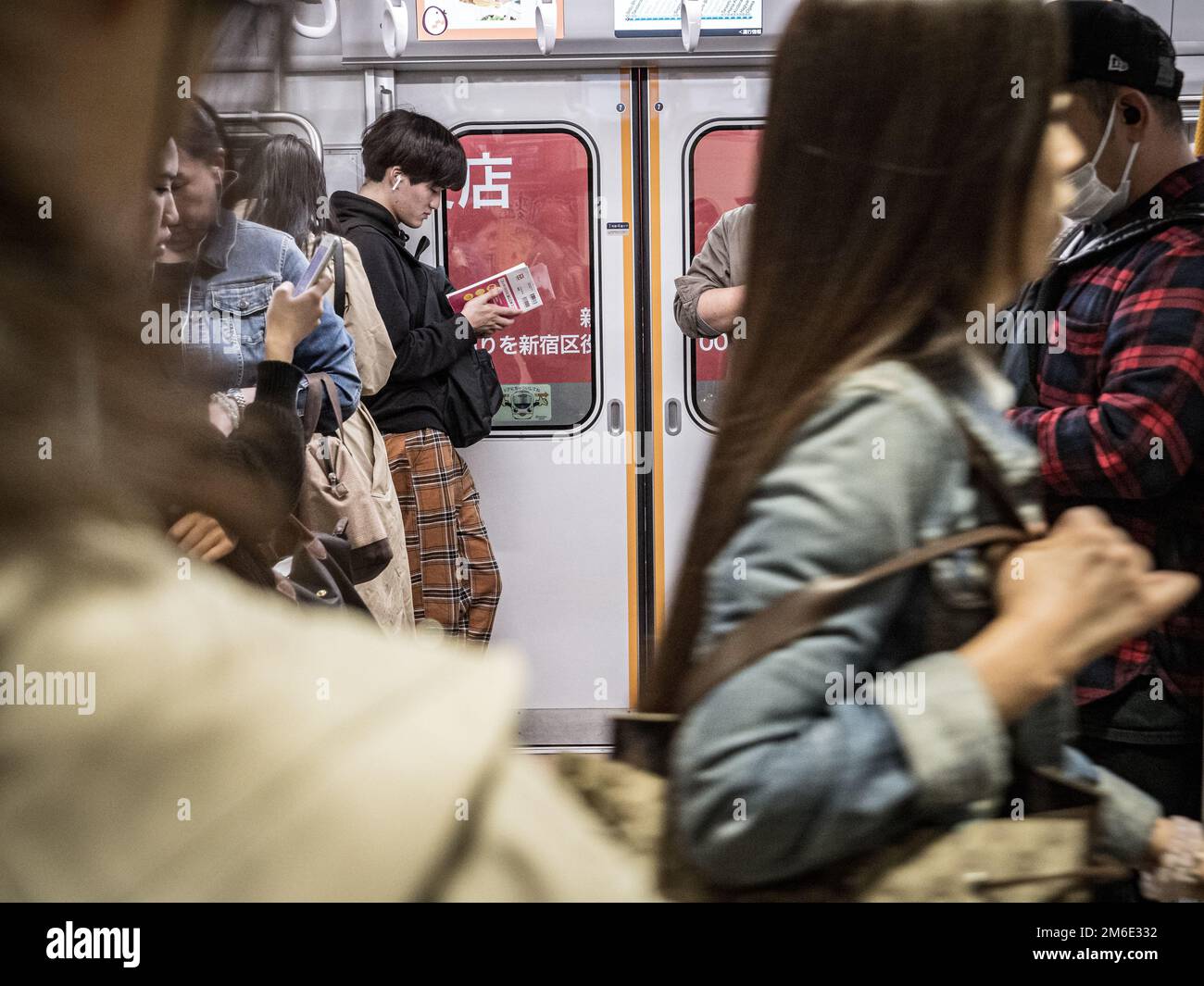 Tokio, Japan - 10 11 19: Menschen, die auf einen geschäftigen Tokioter Zug warten Stockfoto