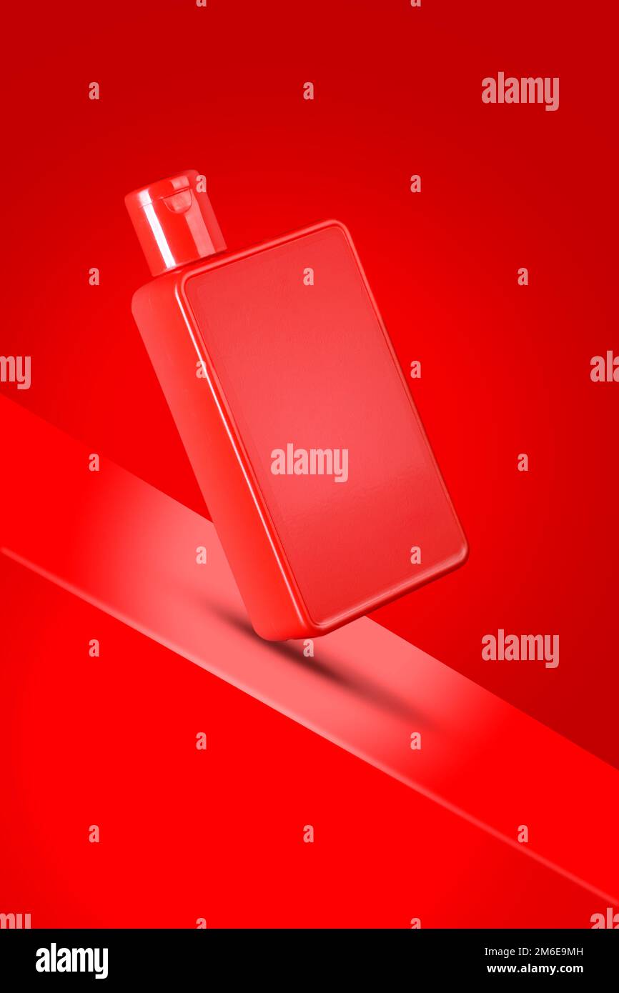Rot gefärbte Desinfektionsmittel / Shampoo / Duschgel Flasche Mockup auf rotem Hintergrund Stockfoto