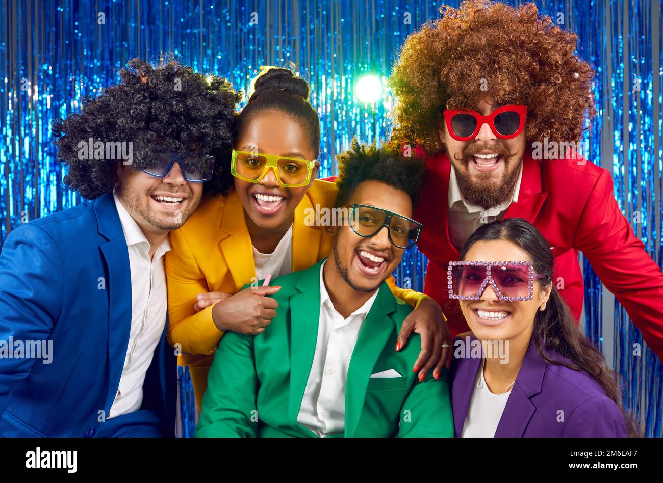 Portrait von glücklichen, vielfältigen Menschen in bunten Kostümen, Partygläsern und lustigen Perücken Stockfoto