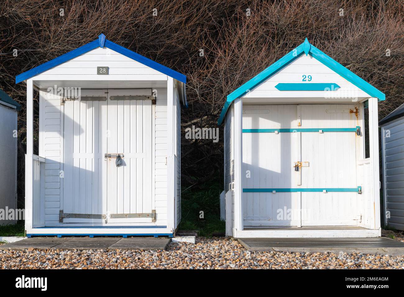 Zwei weiße Holzhütten am Strand von Bexhill-on-Sea an einem sonnigen Tag Stockfoto