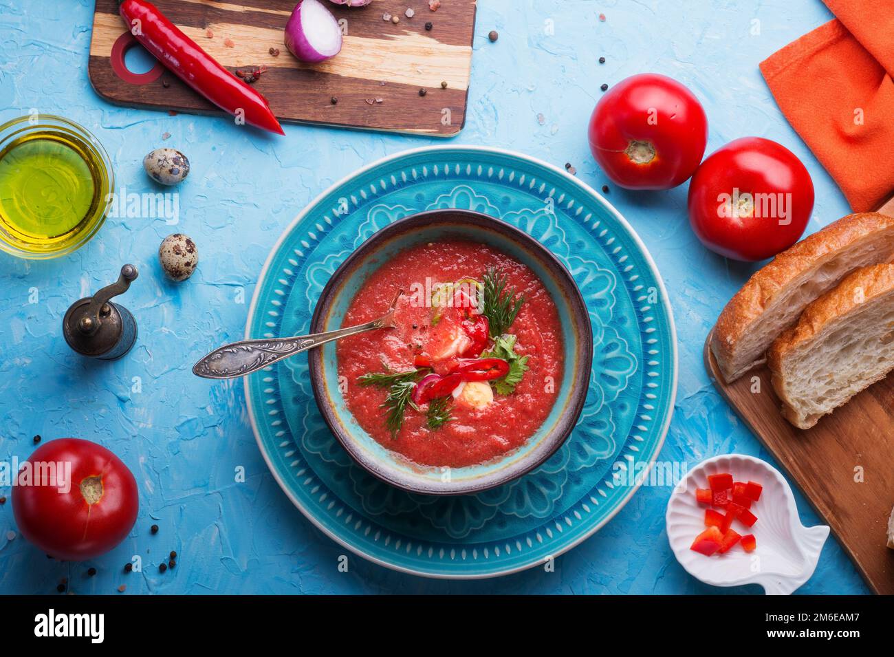 Klassische spanische rohe Suppe Gazpacho, serviert an einem blauen Tisch. Flach verlegt. Speisenrezept. Gesundes Konzept. Stockfoto