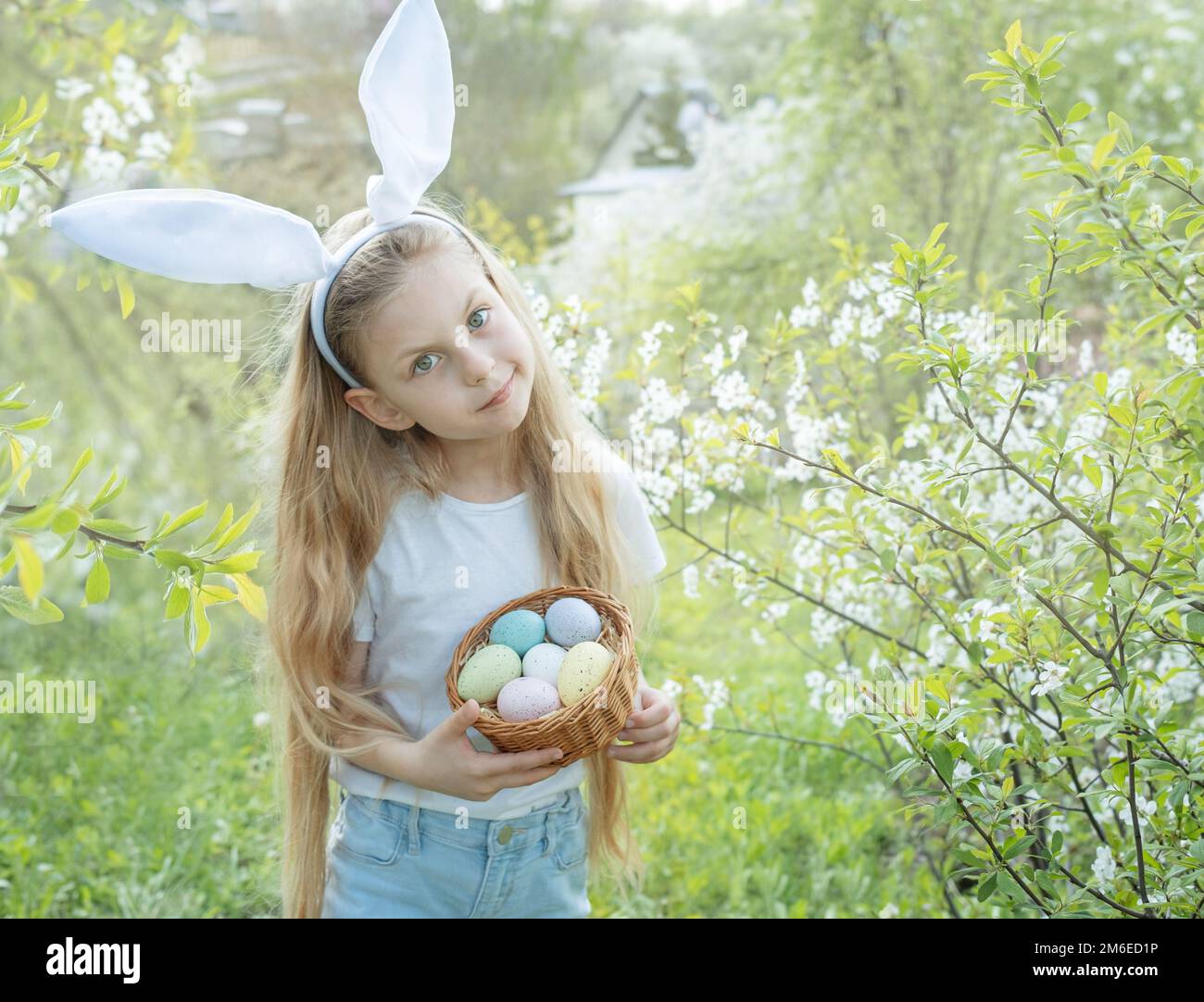 Süßes kleines Kind tragen häschenohren am Ostersonntag. Mädchen mit Korb mit bemalten Eiern. Stockfoto