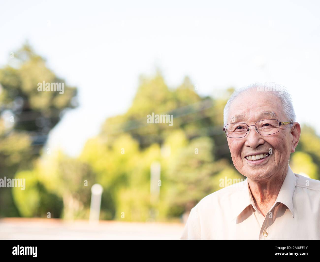 Ein älterer asiatischer Mann lächelt glücklich draußen Stockfoto