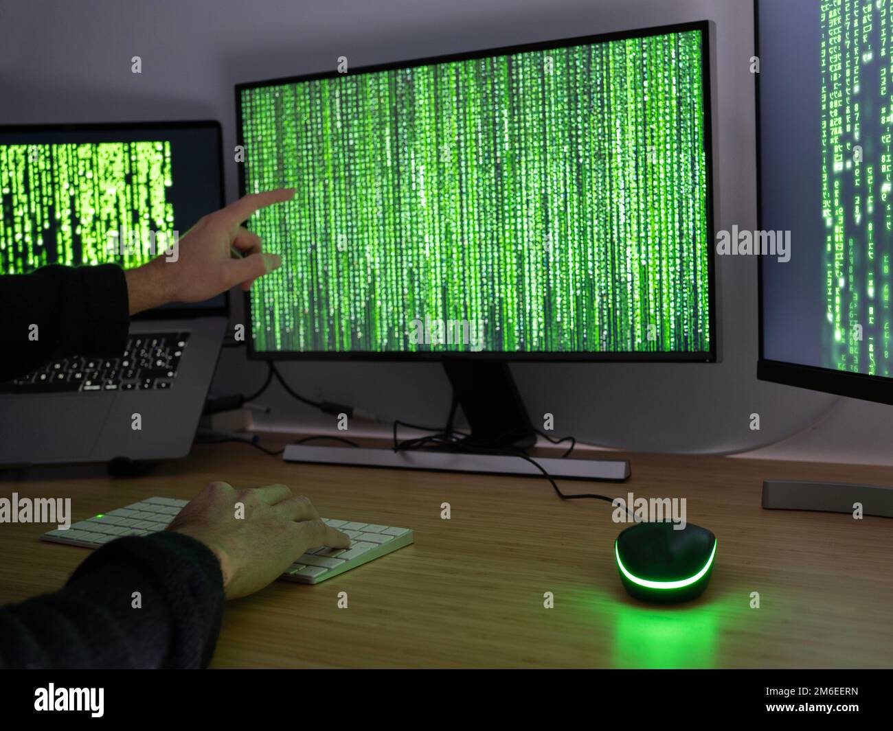 Anonymer Hacker, der mit dem Finger auf den Bildschirm zeigt. Warnkonzept für Sicherheitsmängel im Internet Stockfoto
