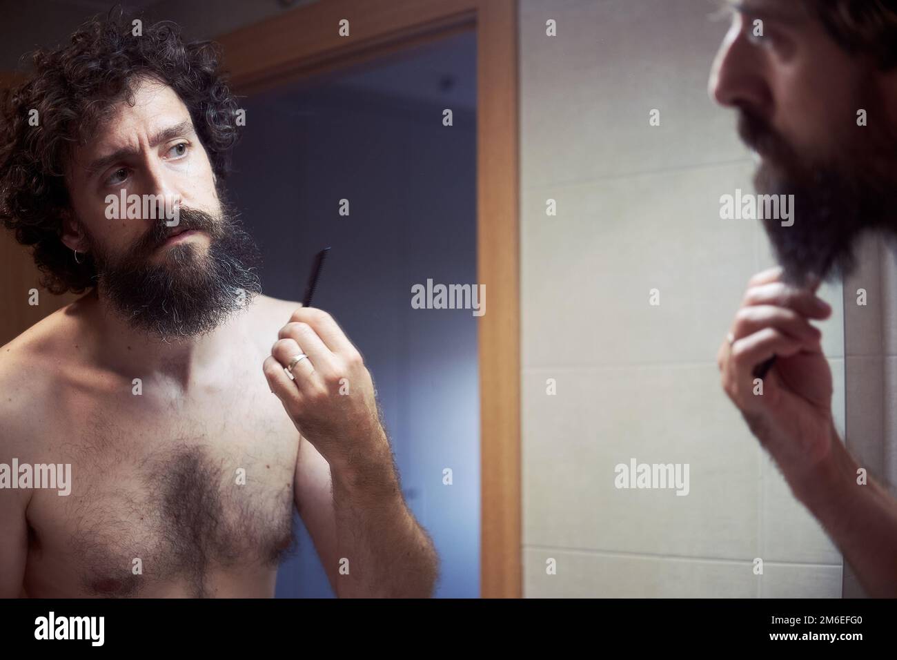 hispanischer Mann mittleren Alters, der sich den Bart schneidet Stockfoto