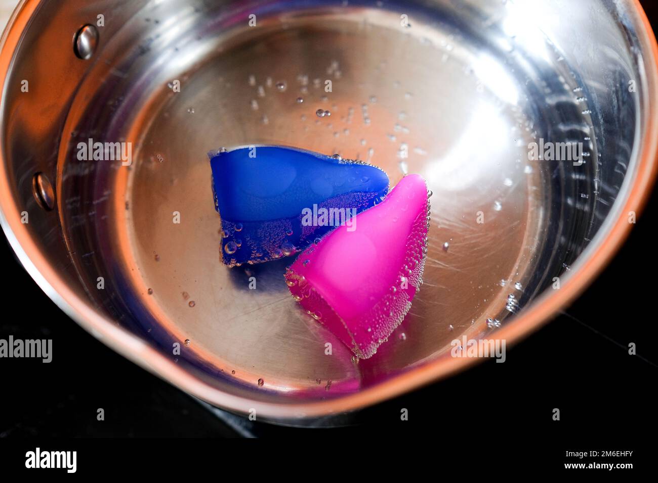 Menstruationstasse in heißem Wasser. Vor dem ersten Gebrauch kochen Stockfoto