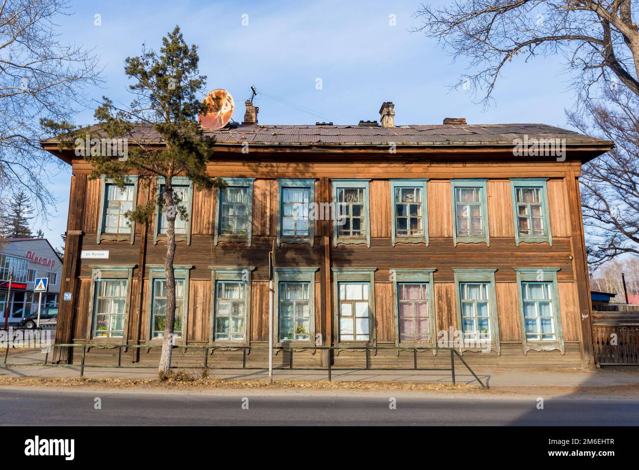 Altes zweistöckiges Wohnhaus aus Holz in der Mitte einer Stadtstraße in Russland Stockfoto