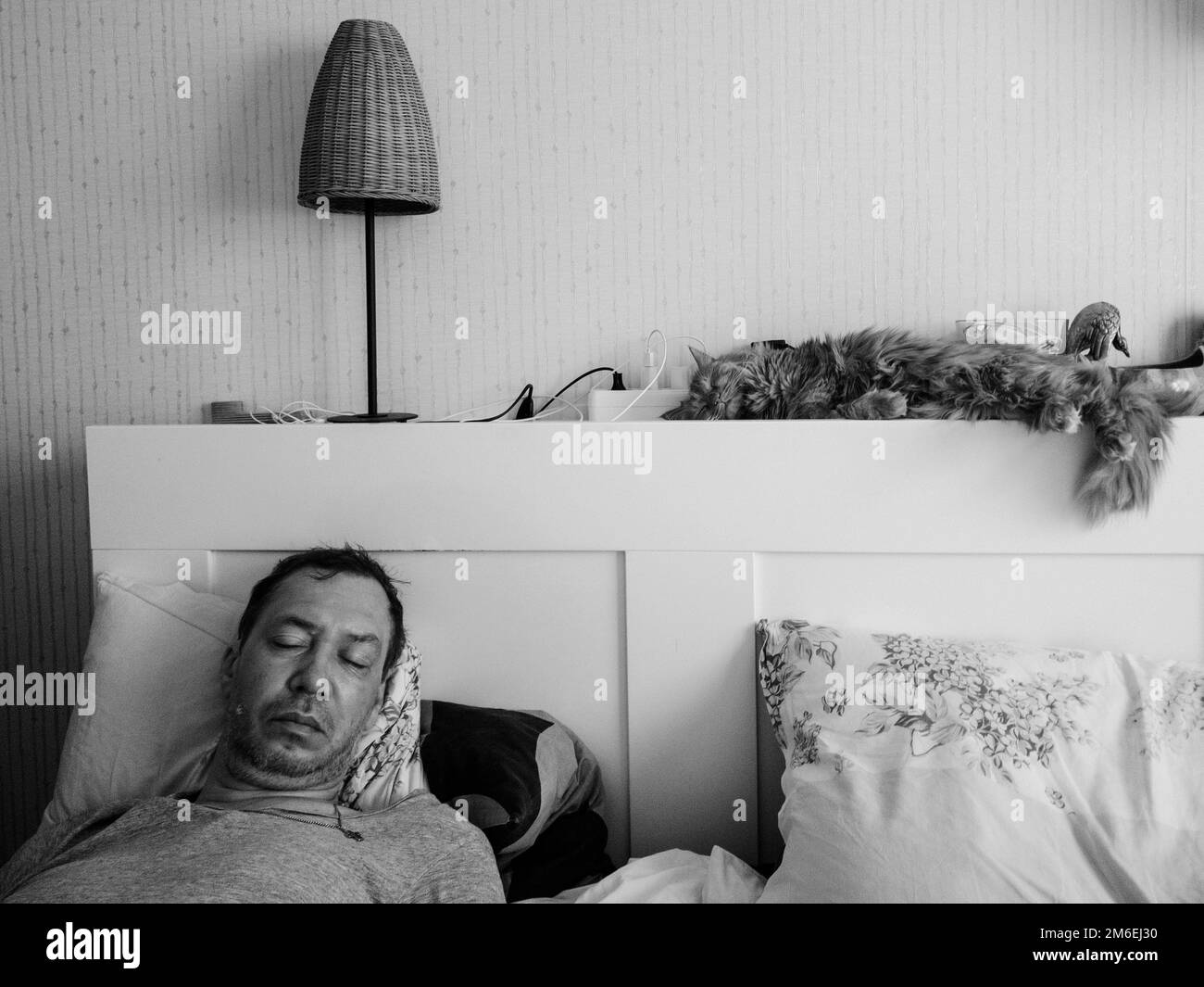Mann schläft beim Telefon im Bett. Stockfoto