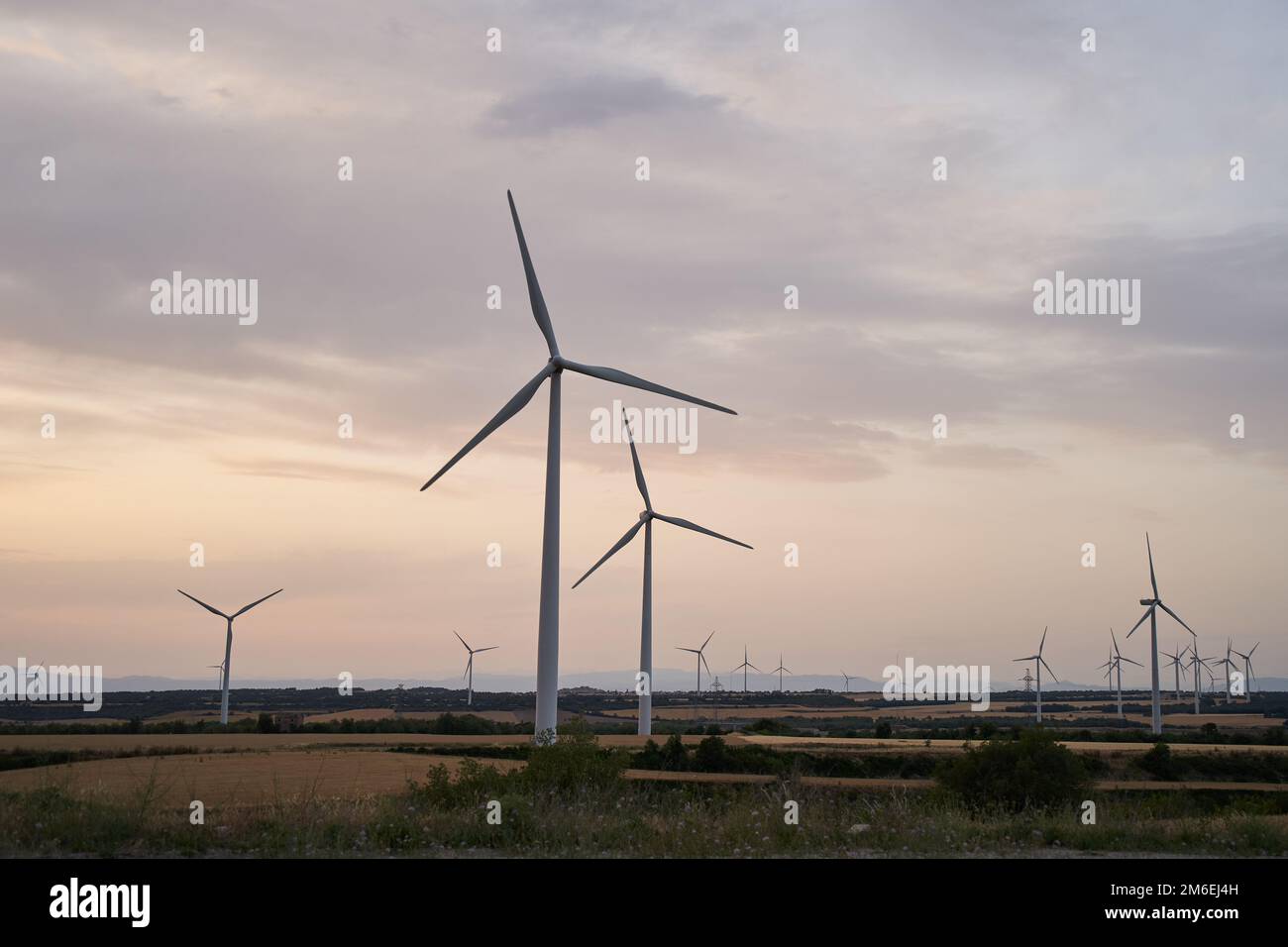 Die Silhouetten der Windturbinenfarm erzeugen am Abend Energie Stockfoto
