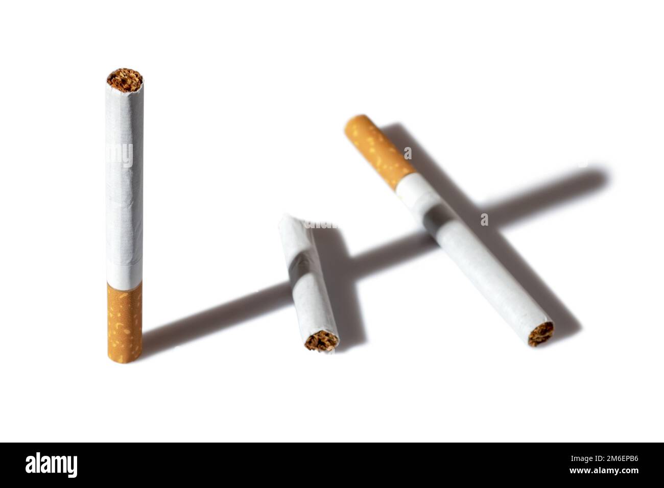 Eine Zigarette mit Schatten, die ein Kreuz auf weißem Hintergrund macht. Stockfoto