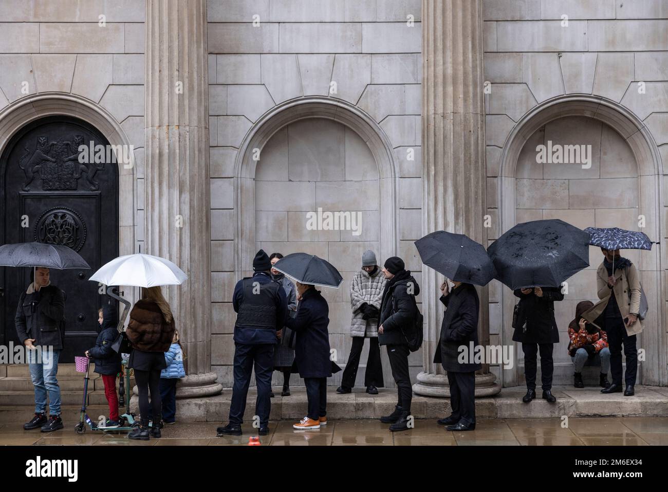 Vor der Bank of England, in der Square Mile, City of London, Großbritannien, ist der Winterregen unter dem Schirm zu spüren Stockfoto