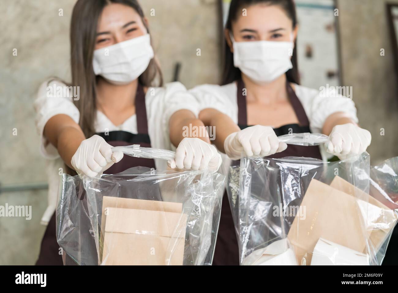 Kellnerin tragen schützende Gesichtsmaske halten Lebensmittelbeutel Stockfoto