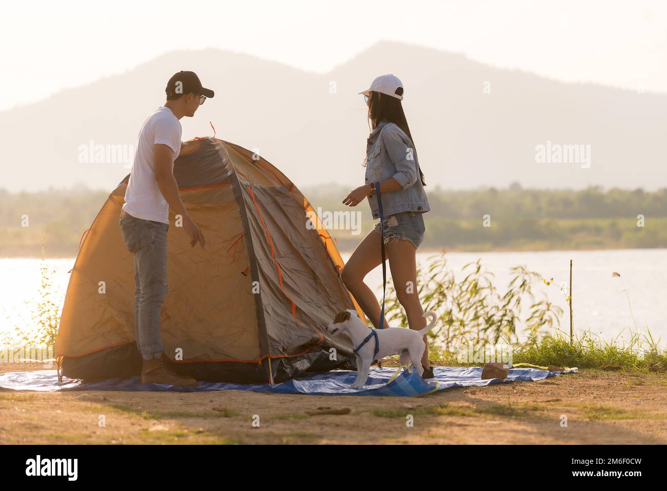 Ein junges, erwachsenes asiatisches Paar baut ein Zelt zum Campen auf Stockfoto