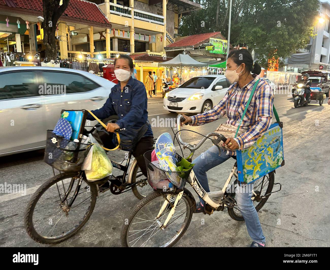 Mueang, Chiang Mai, Thailand, Leute Shopping im Nachtmarkt, Straßenszenen, Frauen Fahrräder mit Gesichtsmasken, öffentlicher Raum Mobilität Ökologie, Autos Stockfoto