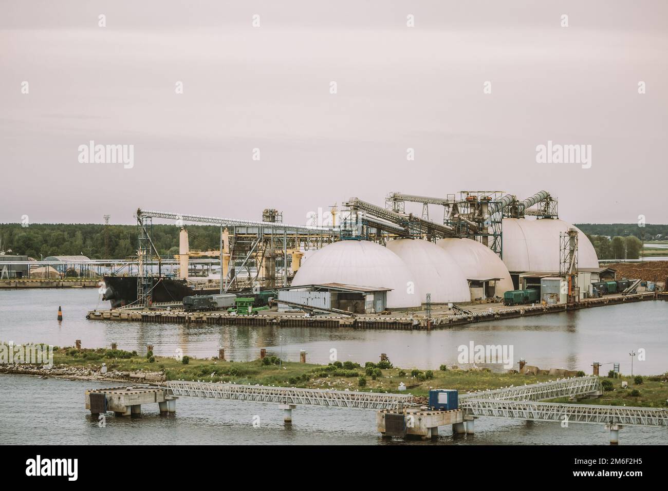 Frachtkräne Im Hafen. Containerterminal. Hafenkrane Und Festgemachtes Frachtschiff Im Hafen. Wirtschaft Und Handel, Logistik. Industrielle Szene Stockfoto