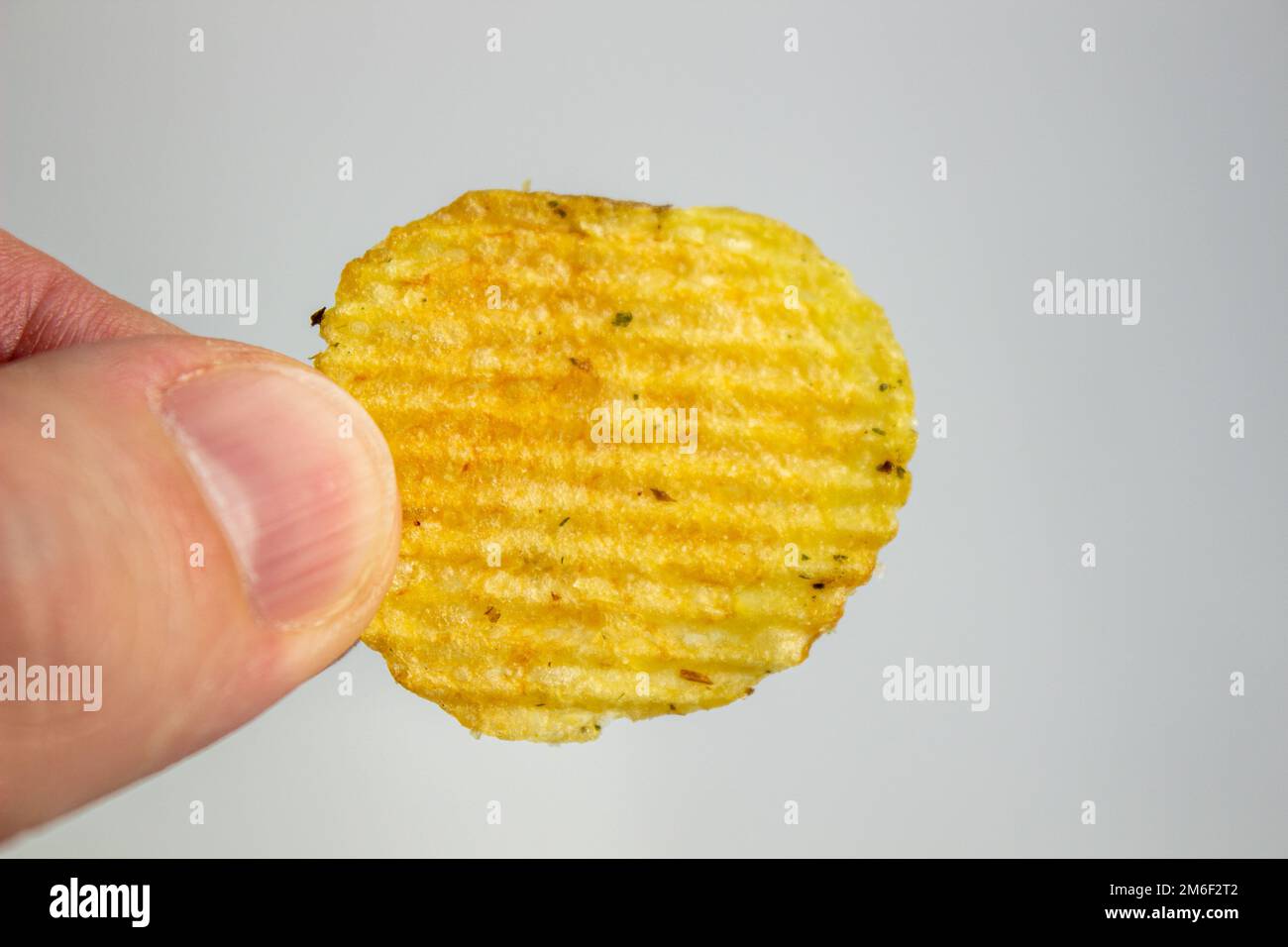 Handgehaltene Kartoffelchips isoliert auf weißem Hintergrund Stockfoto