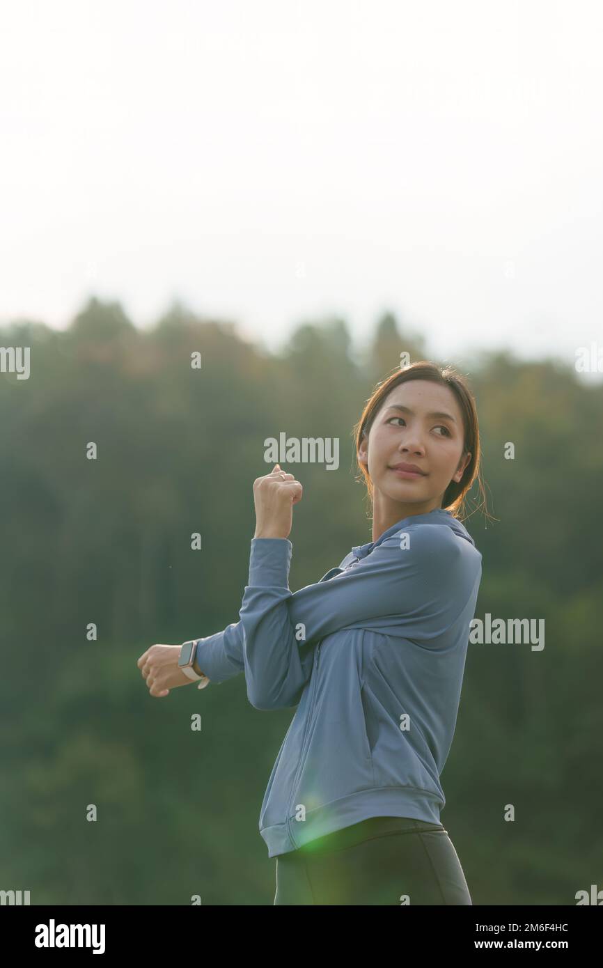 Gesunde Asiatin joggt draußen. Fitness-Girl läuft. Weibliches Training im Outdoor Park Stockfoto