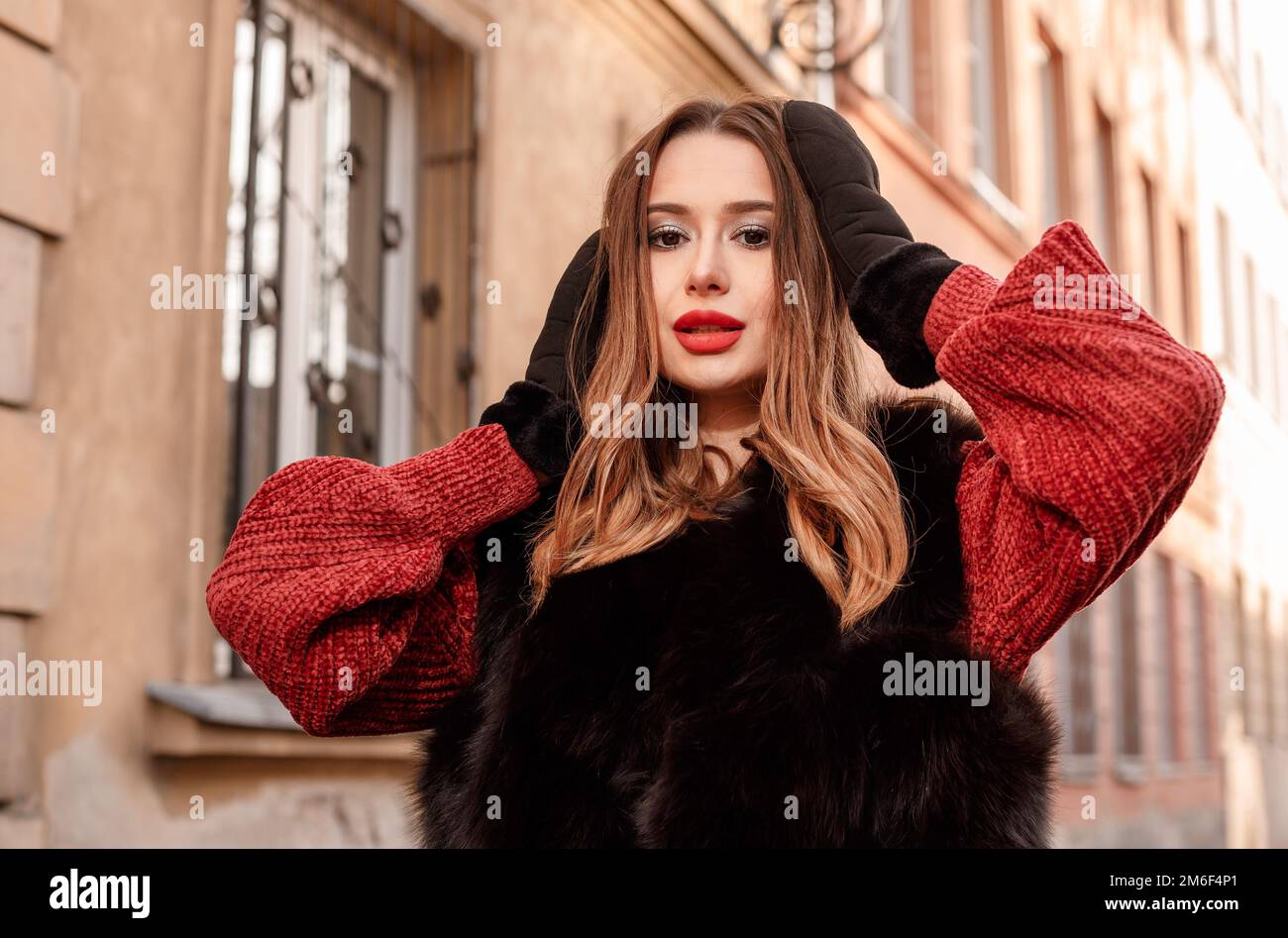 Außenfoto eines modischen weiblichen Models, das im Winterurlaub durch die Stadt spaziert. Modisches Mädchen, das in der Warschauer Straße in O spaziert Stockfoto