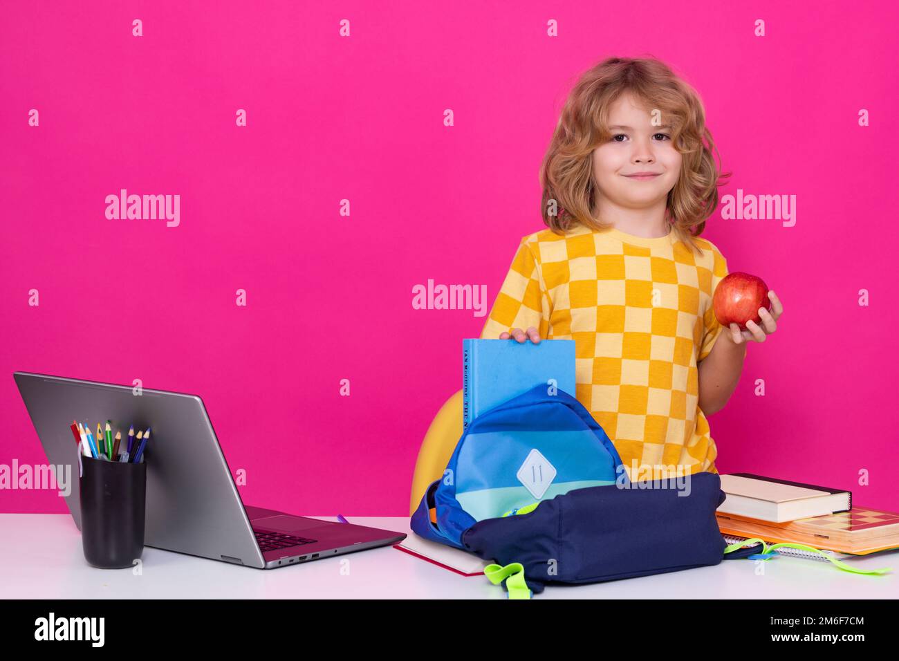 Ein 7-8-jähriges Schulkind mit Buch geht wieder zur Schule. Kleine Schülerin. Stockfoto