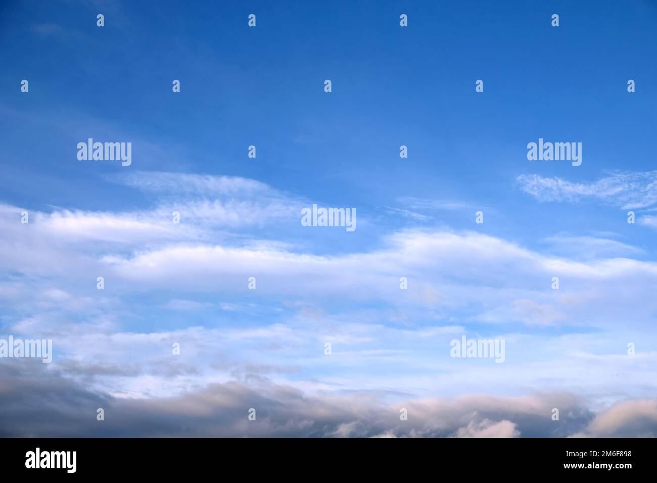 Wunderschöne Himmelslandschaft mit hellen weißen Wolken hoch in der Stratosphäre und dunklen Wolken tief unten an einem sonnigen Tag Stockfoto