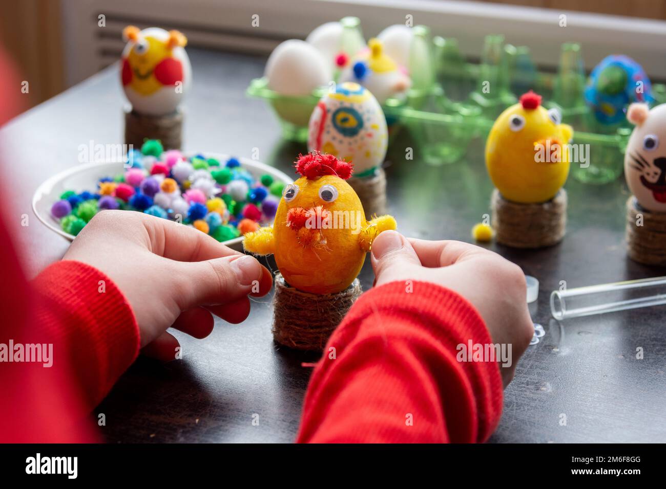 Das Kind beendet die Herstellung einer weiteren Eierschale Figur Ostern zu feiern Stockfoto