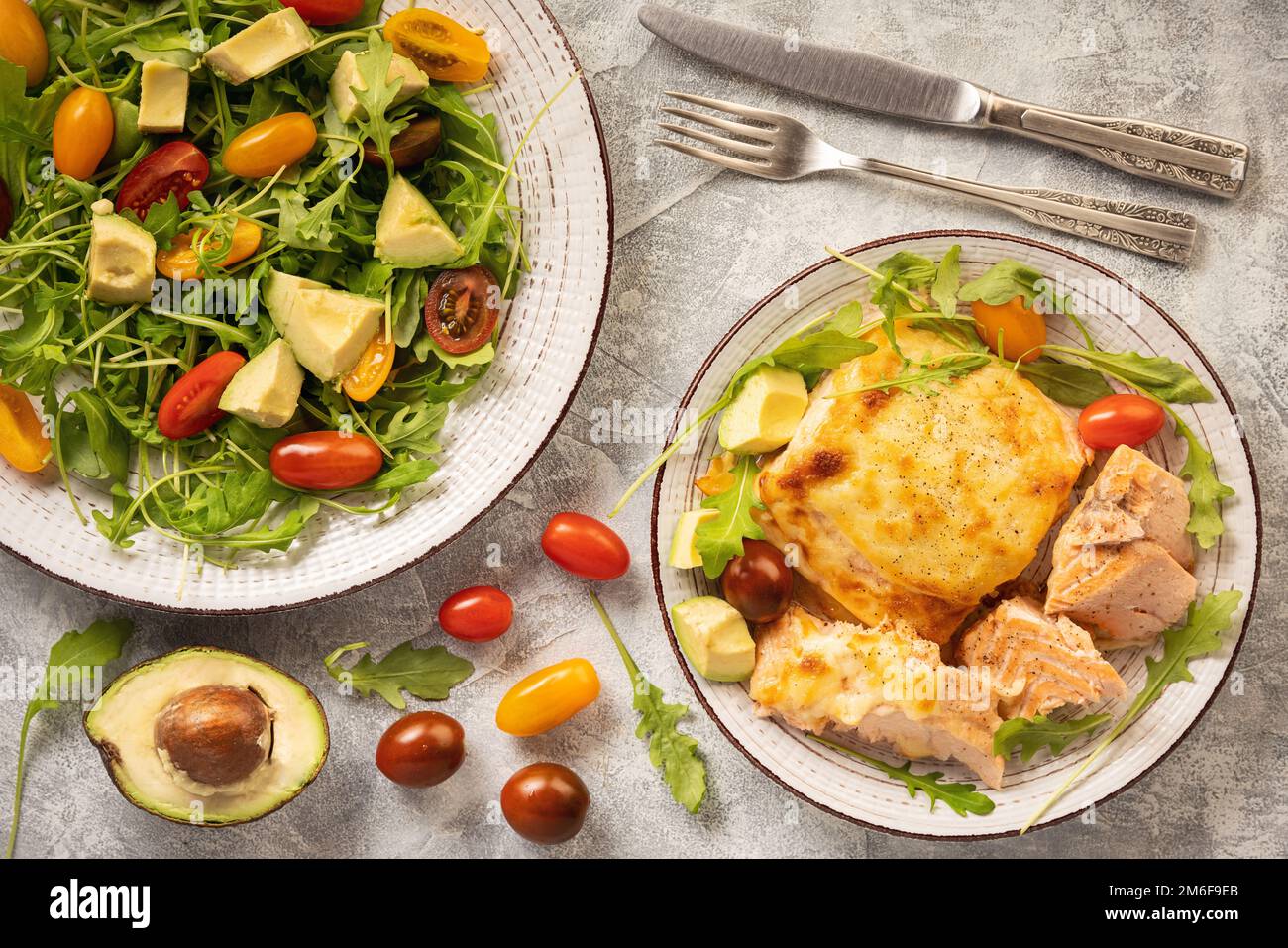 Mit Käse gebackener Lachs, serviert mit Gemüse. Stockfoto