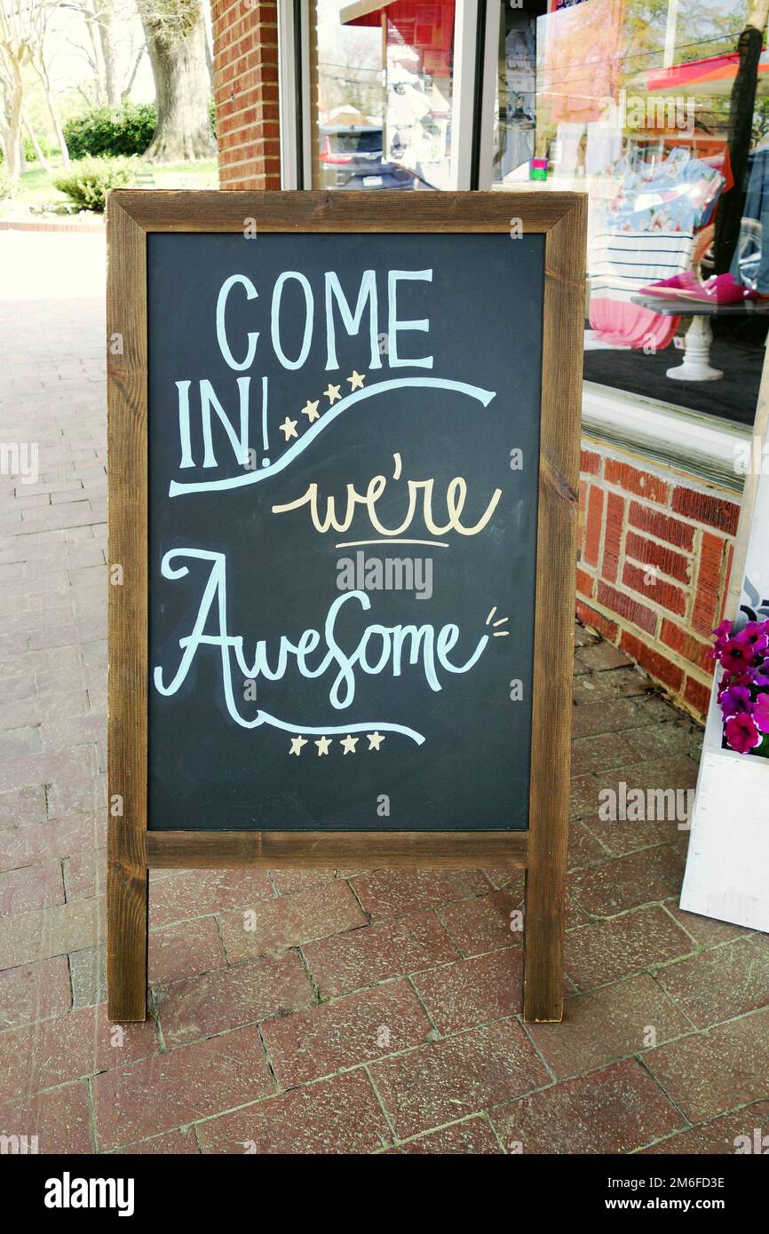 Sandwich-Brett-Schild vor einem kleinen Unternehmen mit "Komm rein" "Wir sind fantastisch" -Nachricht in Kreide geschrieben Stockfoto