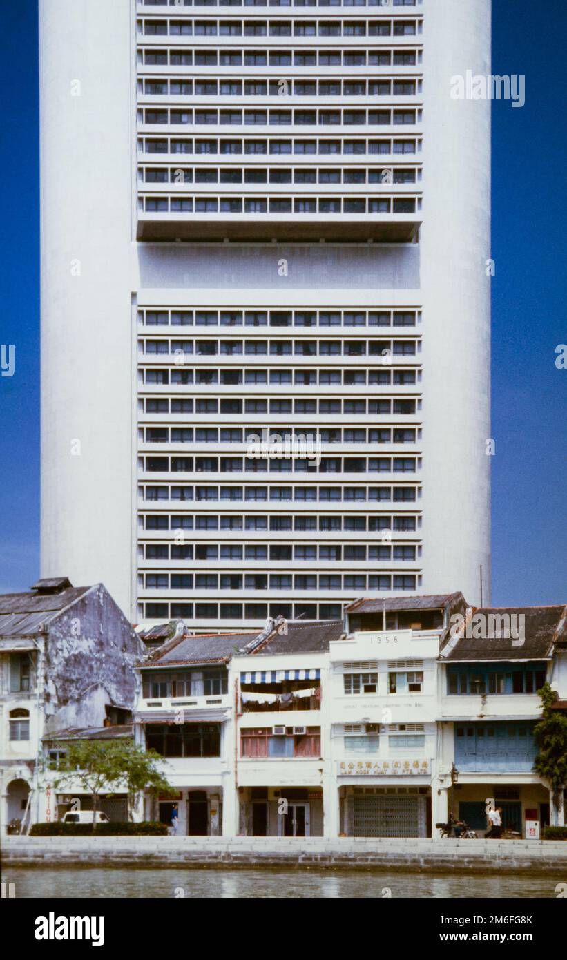 Historischer Archivblick über den Singapore River des Brutalist OCBC Centre Skyscraper, Heimat der OCBC Bank, einst das höchste Gebäude in Singapur und Südostasien, hoch über dem historischen Boat Quay Teil des Alten Hafens von Singapur mit den Orginal Shophouses Lining IT vor der Umgestaltung, Singapur,1990 Stockfoto