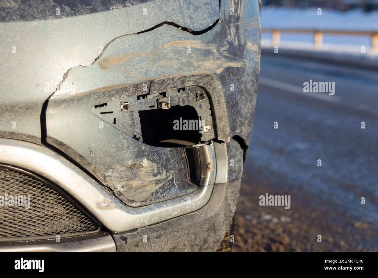 Die Vorderseite des grauen Crossover-Autos wird durch einen Unfall auf der Straße beschädigt. Autoreparatur- oder Kfz-Versicherungskonzept. Vorderer Kotflügel und leichte Schäden und Kratzer Stockfoto