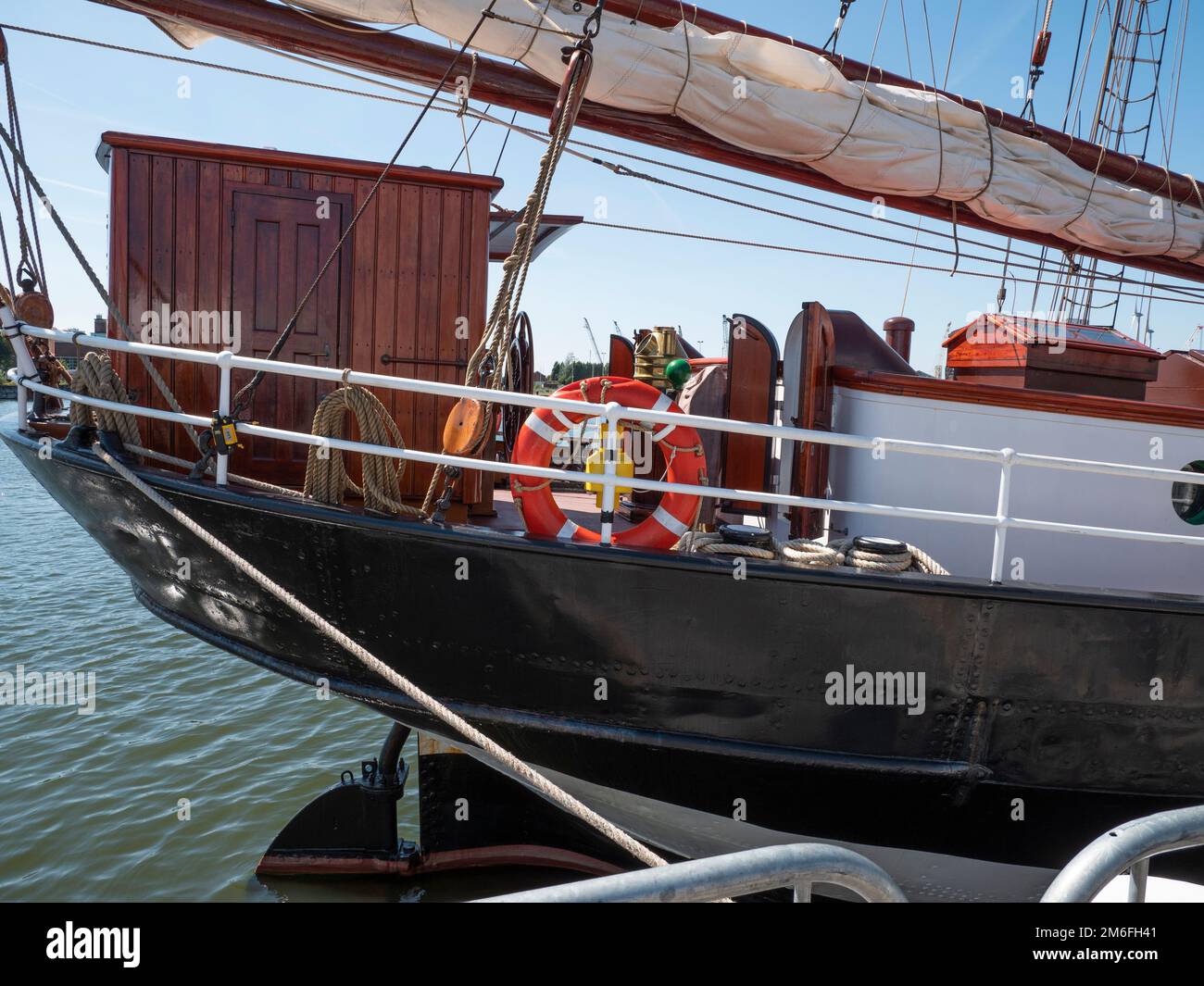 Der Bug eines Segelschiffs mit einer kleinen Holzkabine und einem roten Rettungsring Stockfoto