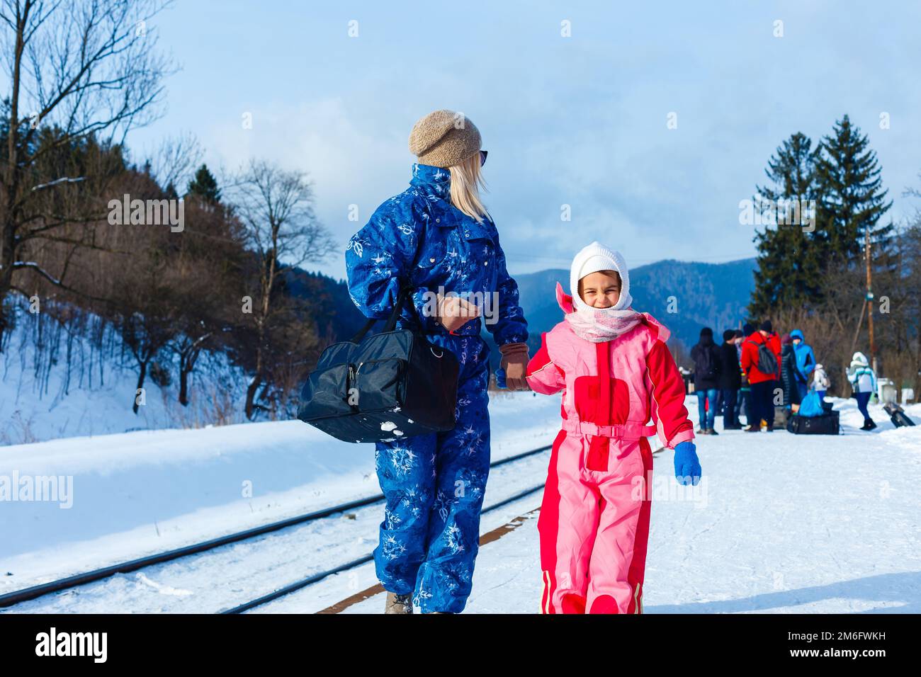 Mutter und Tochter tragen Skianzüge in der Nähe der Eisenbahn Stockfoto